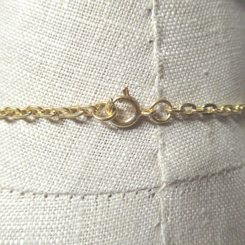 May include: A gold chain necklace with a lobster clasp closure.