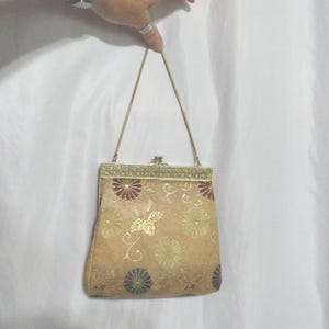 Monedero vintage de tela metalizada dorada con cierre de beso, asa corta de cadena de serpiente, algunas manchas, década de 1950 y 1960.