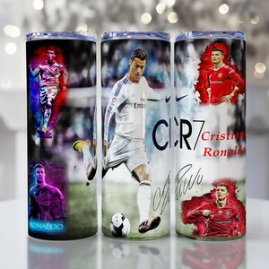 Puede incluir: Tres vasos de acero inoxidable con im&aacute;genes de Cristiano Ronaldo en acci&oacute;n. Cada vaso muestra diferentes fotos del futbolista, con su firma y el texto "CR7" y "Cristiano Ronaldo".