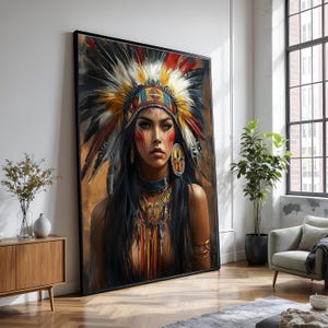 Pode incluir: Retrato emoldurado de uma mulher em traje nativo americano. Ela usa um cocar de penas com detalhes em vermelho, amarelo e branco, além de pintura facial e joias. A obra de arte é exibida em um espaço de convivência moderno com um armário de madeira e uma janela grande.
