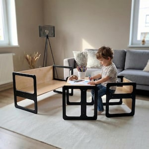 May include: A child's wooden play table and chair set with a natural wood tabletop and black frame. The set is designed for creative activities. The table is approximately 24 inches long and 18 inches wide.