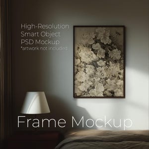 Könnte beinhalten: Ein gerahmter Blumendruck in Sepiatönen hängt an einer Wand. Der Druck ist rechteckig mit einem dunkelbraunen Rahmen. Eine weiße Lampe mit konischem Schirm steht auf einem Nachttisch. Der Text an der Wand lautet "High-Resolution Smart Object PSD Mockup *artwork not included".
