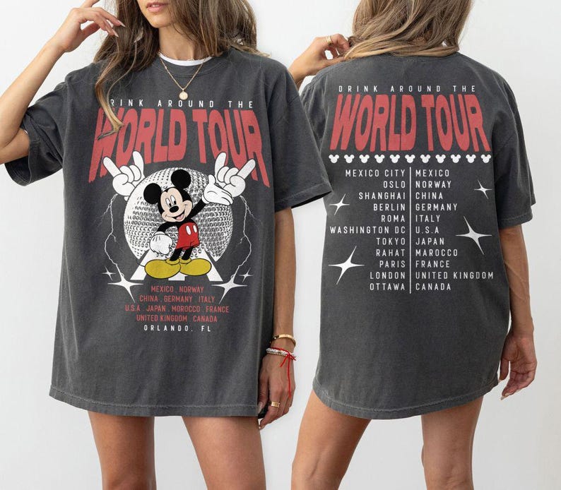 May include: Dark gray t-shirt with a graphic of Mickey Mouse and the text "DRINK AROUND THE WORLD TOUR" in red. The shirt lists cities like Mexico City, Berlin, and Tokyo. The design is on the front and back.