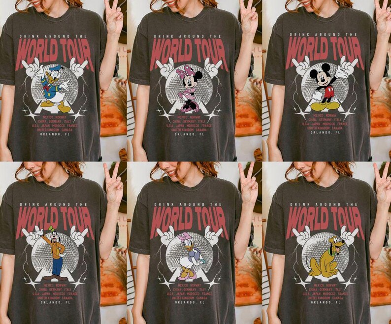 May include: Dark gray t-shirts with various Disney character graphics. Each shirt features the text "DRINK AROUND THE WORLD TOUR" in red, with a character like Donald Duck, Mickey Mouse, or Goofy in a disco ball design. The shirts also list cities like Mexico, Italy, and Orlando, FL.