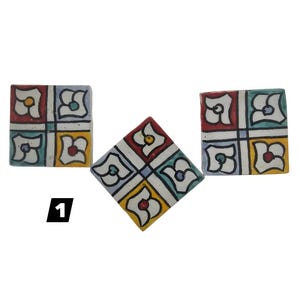 Puede incluir: Tres baldosas de cerámica cuadradas con un diseño floral en rojo, amarillo, azul y blanco. Las baldosas están dispuestas en grupo, con una baldosa girada de lado. El número "1" está impreso en negro.