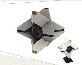 Pode incluir: Uma concha Ghost Generalista geométrica prateada com detalhes laranja e um centro preto. Uma versão menor, branca, com um centro azul também é mostrada. O texto "Generalist Ghost Shell" e "Digital file STL" são exibidos.