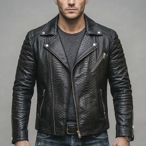 Peut inclure: Une veste de moto noire avec un motif texturé en peau de serpent, un large col cranté avec des boutons-pression en métal argenté, des panneaux d'épaules matelassés et plusieurs poches zippées argentées sur le devant et les manches, portée sur un t-shirt gris.