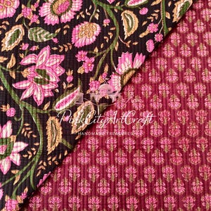 May include: A quilted textile featuring two distinct patterns. One section displays large pink flowers with green stems on a black background. The other section shows a small repeating pink floral print on a maroon background. Text reads Pink City ArtCraft.