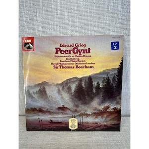 May include: A vintage LP record titled "Peer Gynt" by Edvard Grieg. The album cover features a landscape painting with trees and mountains. The text includes the names of the performers and the label "EMI".