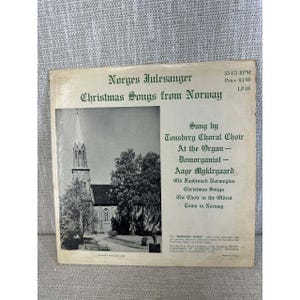 May include: Vintage LP record titled "Norges Julesanger Christmas Songs from Norway." The album cover features a black and white image of a church and text in green. The record is 33-1/3 RPM.