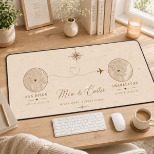 Può includere: Un tappetino da scrivania rettangolare con sfondo beige chiaro, un design a mappa, due inserti circolari con le mappe di San Diego e Charleston, una rosa dei venti, una rotta di volo tratteggiata con un cuore e il testo Mia & Carter Miles Apart Always Close.