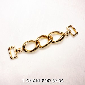 May include: A gold-colored chain link connector with three oval links and rectangular end pieces. The chain is shown on a white background. The text "1 CHAIN FOR $2.95" is at the bottom of the image.