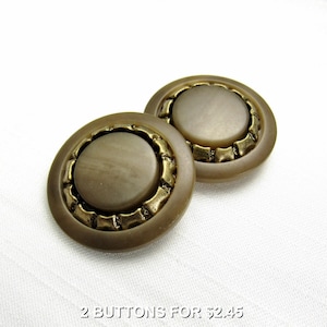 May include: Two brown plastic buttons with a gold rim. The buttons have a raised, circular center.