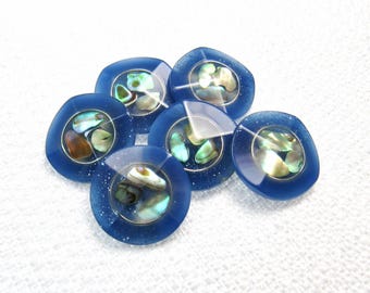 May include: A set of six round buttons featuring a deep blue translucent resin border with subtle glitter accents. Each button has a circular center inlay filled with iridescent, multi-colored crushed shell fragments that display green, blue, and brown tones.