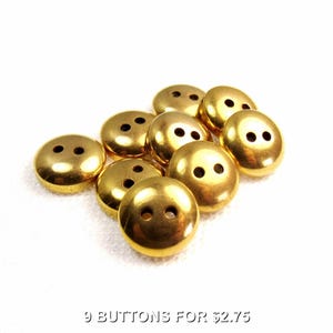 May include: Nine gold-colored buttons with two holes each. The buttons are arranged in a cluster on a white background. The text "9 BUTTONS FOR $2.75" is visible below the buttons.
