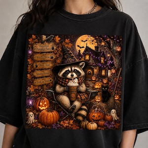 May include: A black t-shirt featuring a graphic of a raccoon wearing a witch hat and scarf, holding a coffee cup. The scene includes a wooden sign with text: Haunted Pumpkin Patch, Witch's Brew, Ghost Trail, Spooky Forest, and Trick or Treat.