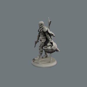 K&ouml;nnte beinhalten: Graue Figur von The Mandalorian mit einem Blaster und Grogu in einer Wiege. Der Mandalorianer tr&auml;gt eine R&uuml;stung und einen Helm. Die Figur steht auf einem runden Sockel.