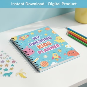 Peut inclure: Un agenda à spirales avec une couverture bleu clair portant l'inscription "MY AWESOME KIDS PLANNER" et des illustrations de fusées, de planètes et d'étoiles. L'image comprend également des crayons de couleur, des autocollants et un autocollant banane.