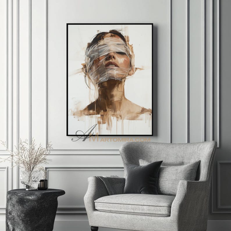 May include: An abstract painting in a black frame depicts a person with their eyes covered by white tape. The artwork uses a muted color palette of browns and whites, creating a sense of mystery and introspection. The painting is displayed on a white wall.