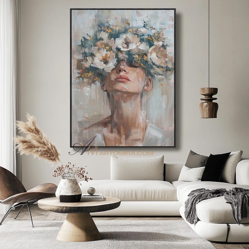 K&ouml;nnte beinhalten: &Ouml;lgem&auml;lde einer Frau mit Blumenkrone in einer neutralen Farbpalette. Das Kunstwerk zeigt das Gesicht und den Hals einer Frau, mit einer gro&szlig;en Anordnung wei&szlig;er und beiger Blumen, die ihre Augen bedecken. Das Gem&auml;lde ist schwarz gerahmt.