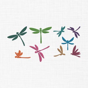 May include: A collection of colorful dragonfly designs in various shades, including green, blue, purple, orange, and pink. The dragonflies are arranged on a white textured background.
