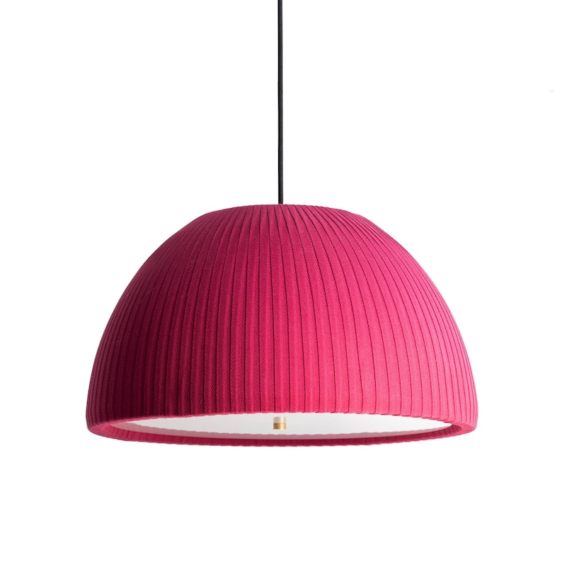 May include: A vibrant fuchsia pendant light with a pleated fabric shade. The dome-shaped shade hangs from a black cord, revealing a white interior and a brass-colored fixture. The light fixture is a modern design.