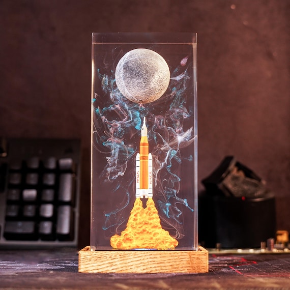 A handcrafted resin lamp capturing the Artemis II rocket launch scene — glowing NASA-inspired desk art that's genuinely one-of-a-kind and makes a killer gift for space nerds.