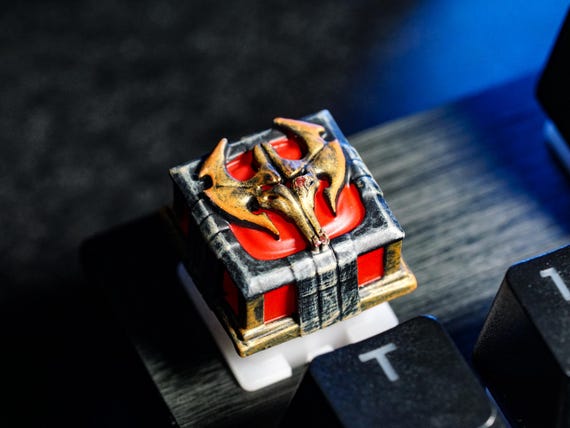 A hand-sculpted resin dragon coiled around a keycap — tiny wearable fantasy art that replaces one key on your keyboard with a conversation-stopping miniature sculpture.