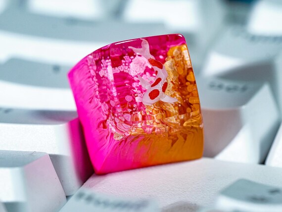 A hand-crafted resin keycap with a koi fish suspended inside — like a tiny Japanese pond living on your spacebar.