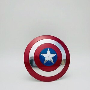 May include: A red, white, and blue Captain America shield. The shield is round with a red outer ring, a silver middle ring, and a blue center with a white star. The shield is a prop or collectible.