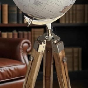 May include: A vintage-style globe with a detailed map of the world, mounted on a wooden tripod stand. The globe features a cream-colored surface with brown and tan continents. The stand has wooden legs and metal accents, creating a classic aesthetic.