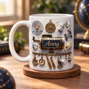 Può includere: Una tazza in ceramica bianca con un design spaziale in rilievo tridimensionale. La tazza presenta un telescopio nero centrale con il nome Avery stampato in oro, circondato da pianeti, una bussola, guanti da astronauta e una parabola.