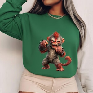 May include: Green sweatshirt with a detailed illustration of an angry monkey. The monkey has red and grey fur, spiked wristbands, and a red mohawk. The sweatshirt has a green body and white sleeves.