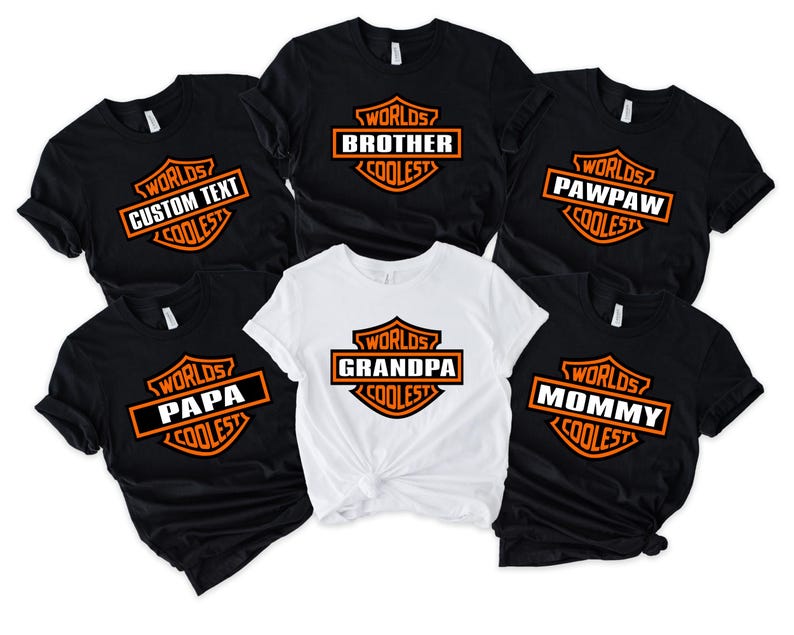 May include: A collection of black and white t-shirts with orange and white text. The shirts feature the phrase "Worlds Coolest" above various family titles like "Brother", "Grandpa", and "Mommy". The shirts are short-sleeved.