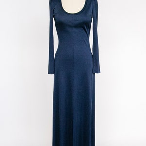 Puede incluir: Un vestido largo de color azul marino con mangas largas y cuello redondo. El vestido est&aacute; ajustado en el corpi&ntilde;o y se ensancha en una falda completa.