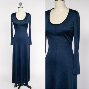 Puede incluir: Un vestido largo de manga larga de color azul oscuro. El vestido tiene un escote redondo y un corpi&ntilde;o ajustado. Las mangas son largas y fluidas.