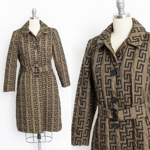 May include: A brown quilted coat with a black geometric pattern and a black belt. The coat has a button closure and a collar.
