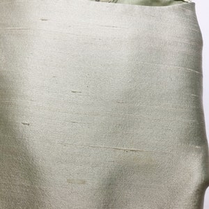 May include: A light green satin skirt with a zipper closure and a label that reads "Frederick Nelson" in black text.