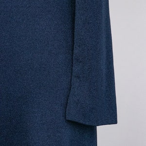 Puede incluir: Un vestido largo de manga larga de color azul oscuro con tejido de punto texturizado.