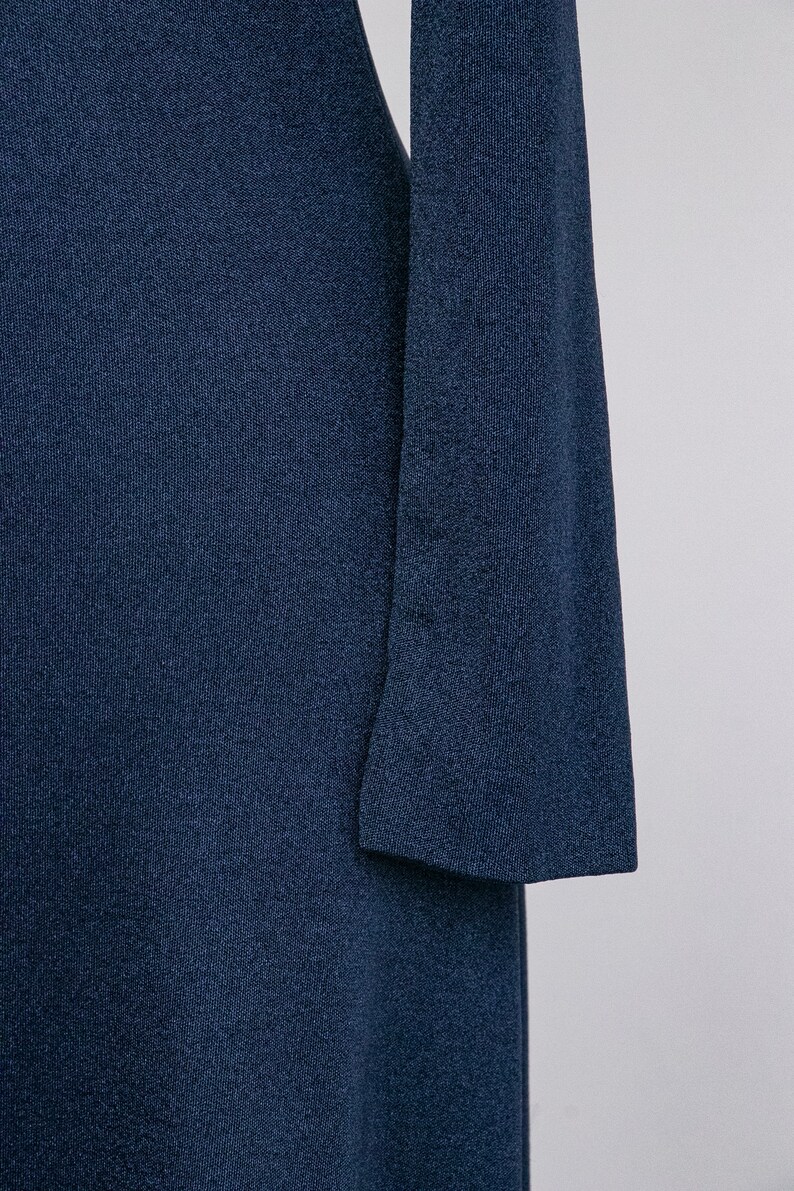 Puede incluir: Un vestido largo de manga larga de color azul oscuro con tejido de punto texturizado.