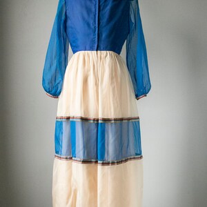 May include: A long, blue and cream dress with a large collar and a tiered skirt. The skirt has blue and brown stripes.