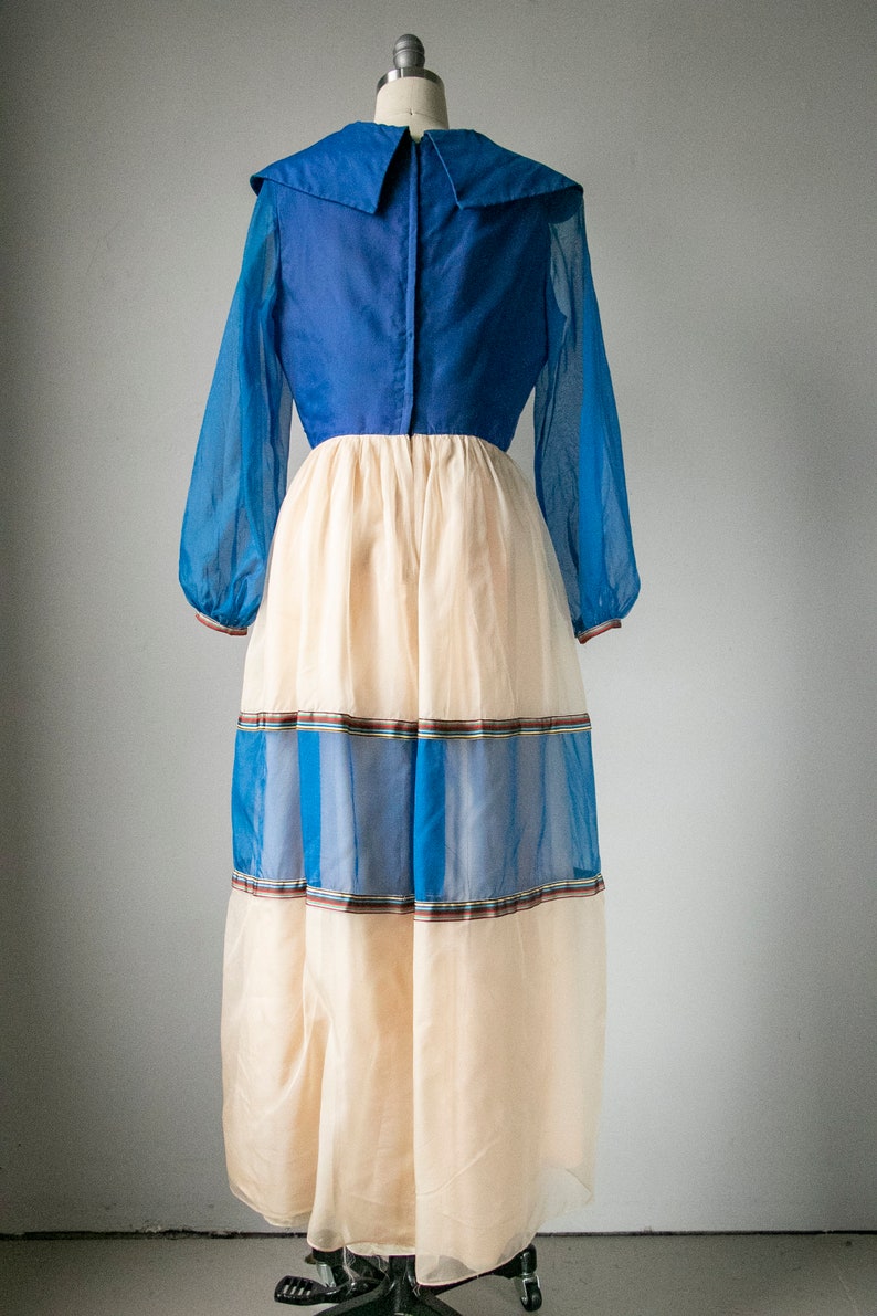 May include: A long, blue and cream dress with a large collar and a tiered skirt. The skirt has blue and brown stripes.