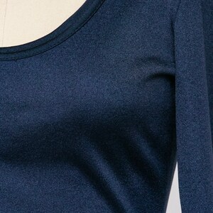 Puede incluir: Una camisa de manga larga azul marino con cuello redondo.