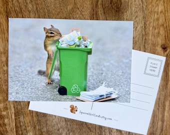 May include: A postcard featuring a chipmunk standing next to a miniature green recycling bin filled with tiny items. The back of the postcard includes a small illustration of a chipmunk and the text SquirrelGirlCards.etsy.com.