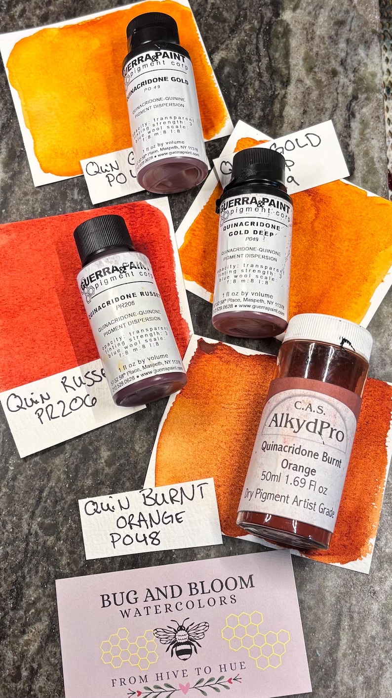 May include: An assortment of watercolor pigment bottles and swatches in shades of orange and red. The bottles are labeled with pigment names like Quinacridone Gold and Quinacridone Burnt Orange. The image also includes a card that says "Bug and Bloom Watercolors".