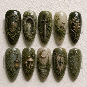 May include: A set of ten almond-shaped press-on nails featuring intricate 3D designs in shades of forest green, cream, and metallic gold. The motifs include a shield, stone archway, sword, mushrooms, oak leaves, lantern, moon, and fleur-de-lis.