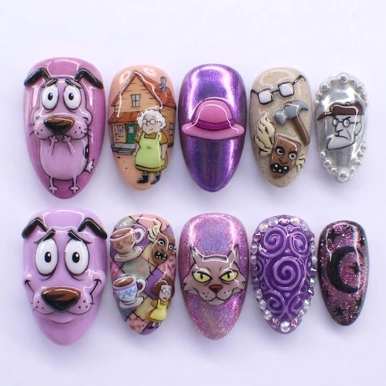 Op de afbeelding: Een set van tien press-on nagels met personages en thema's uit Courage the Cowardly Dog. De ontwerpen bevatten Courage, Muriel, Eustace, de boerderij en diverse op de serie ge&iuml;nspireerde motieven zoals theekopjes, een masker en een kat, in paars en roze.