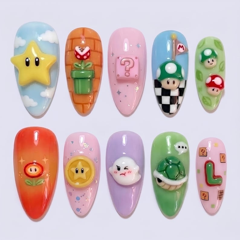 May include: A set of ten almond-shaped acrylic nails, each with a different design inspired by the Super Mario video game. Designs include a yellow star, a question mark block, and a green turtle.