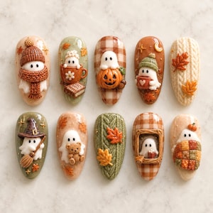 Puede incluir: Un conjunto de diez uñas postizas en forma de almendra con diseños otoñales en 3D. La colección incluye fantasmas blancos con gorros y bufandas de punto, fantasmas con calabazas, un fantasma brujo con escoba, un fantasma con un osito de peluche y texturas de punto trenzado con hojas de arce naranjas y marrones.
