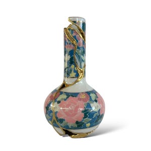 Puede incluir: Jarrón de cerámica decorativo con base bulbosa y cuello largo. Presenta un patrón floral en rosa, azul y verde, con detalles dorados. El jarrón muestra reparaciones kintsugi doradas, una técnica japonesa.